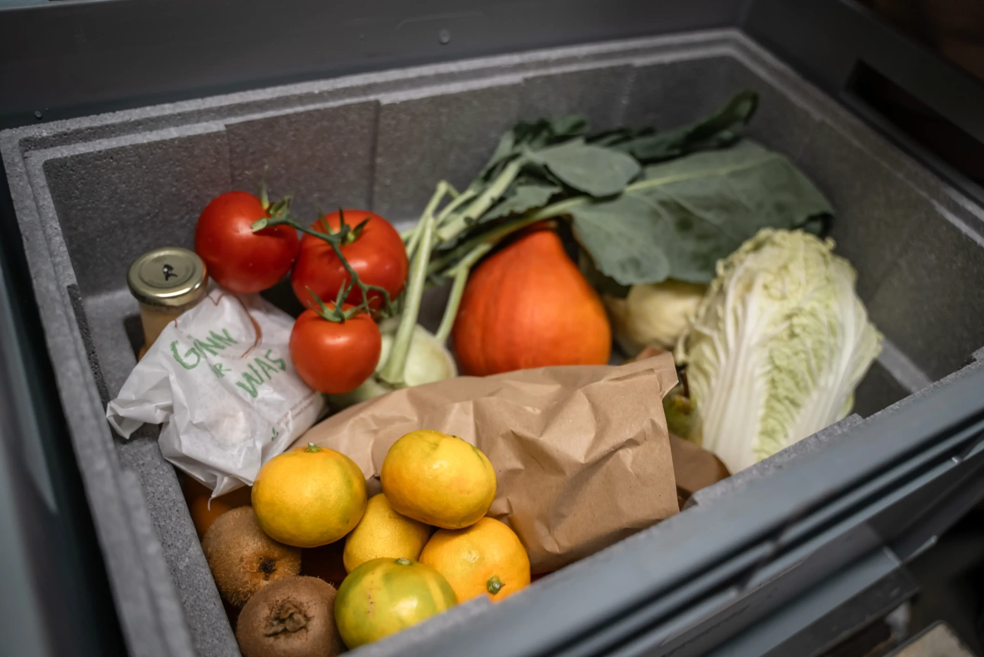 Gepackte Box mit Hokkaido, Tomaten, Orangen und Chinakohl